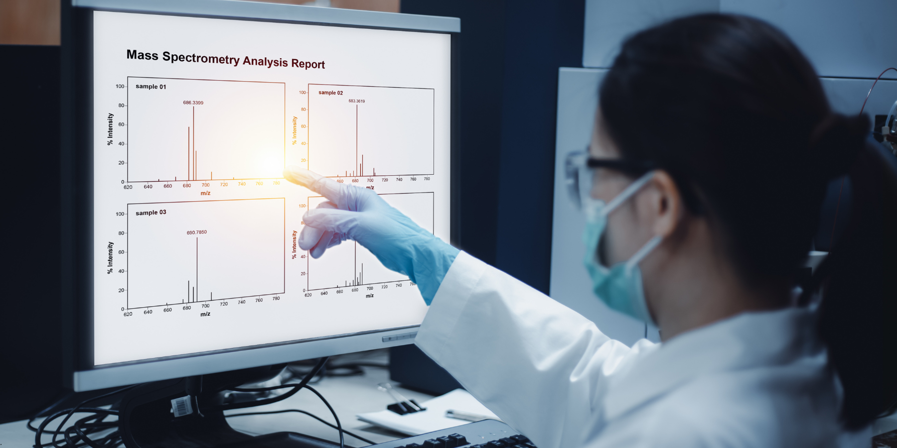 Woman looking at a computer screen with mass spectrometry analysis Woman looking at a computer screen with mass spectrometry analysis