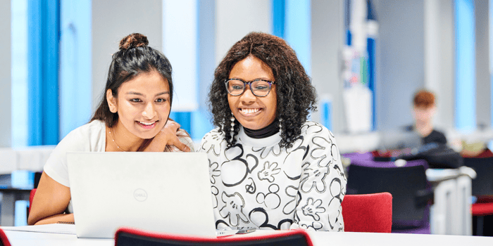 Two women looking at a laptop screen
